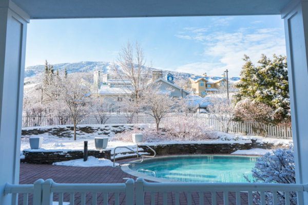 View out a window of a hot tub with ski slopes in the distance